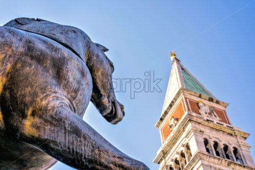 Daylight view to Horses of Saint Mark with campanile on background. Bright blue clear sky. Negative copy space, place for text. Venice, Italy - Starpik