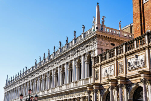 Daylight view to Marciana Library renaissance style facade and campanile entrance from Saint Mark’s square. Bright blue clear sky. Negative copy space, place for text. Venice, Italy - Starpik