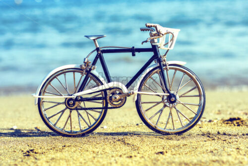 Daylight view to handicraft bicycle souvenir on beach sand. Sea on background. Negative copy space, place for text. Limassol, Cyprus - Starpik