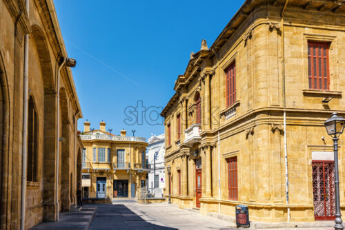 Daylight view to old city streets with stone ornamented buildings and tourists walking. Bright blue clear sky. Negative copy space, place for text. Nicosia, Cyprus - Starpik