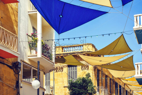 Daylight view to sun shades above Ledra street. Stone ornamented buildings on background. Bright blue clear sky. Negative copy space, place for text. Nicosia, Cyprus - Starpik