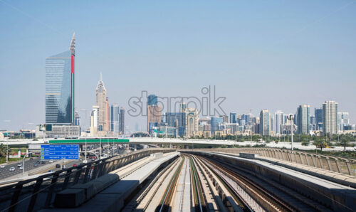 Dubai Metro railroad with cityscape on background. Clear sky. United Arab Emirates - Starpik