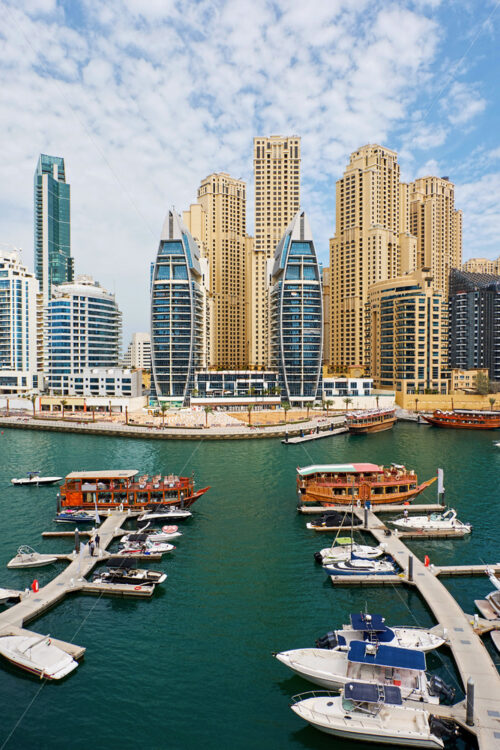 Dubai marina cityscape at daylight. Clear sky. United Arab Emirates. Yachts parked in port. - Starpik