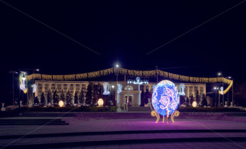 Easter egg on the background of the arch of triumph at night in Chisinau, Moldova - Starpik