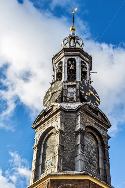 Famous Mint Tower at sunset from bottom. Bright blue sky with clouds on background. Amsterdam, Netherlands - Starpik