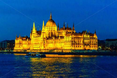 Famous parliament at night blue hour. Warm yellow lights glowing on building. Danube river with reflections. Negative copy space, place for text. Budapest, Hungary - Starpik