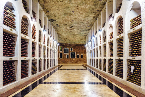 Famous wine cellars in wide perspective. Bright lights illuminating interior. Old stone ceiling. Cricova, Moldova - Starpik