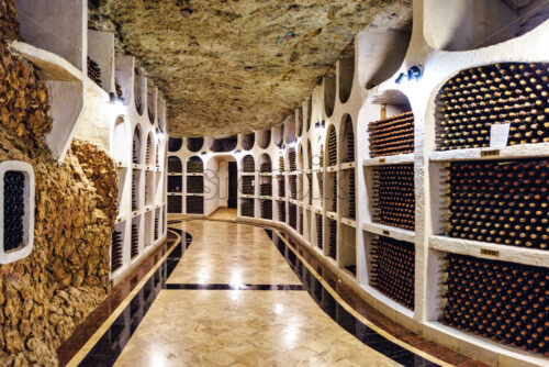 Famous wine cellars in wide perspective. Bright lights illuminating interior. Old stone ceiling. Cricova, Moldova - Starpik