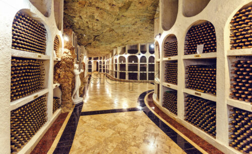 Famous wine cellars in wide perspective. Bright lights illuminating interior. Old stone ceiling. Cricova, Moldova - Starpik