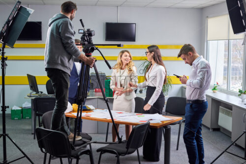 Film director discussing movie plan with the actors in the office scene. Lights pointing to the actors - Starpik