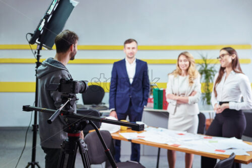 Film director discussing movie plan with the actors in the office scene. Lights pointing to the actors - Starpik