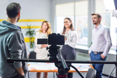 Film director discussing movie plan with the actors in the office scene. Lights pointing to the actors - Starpik