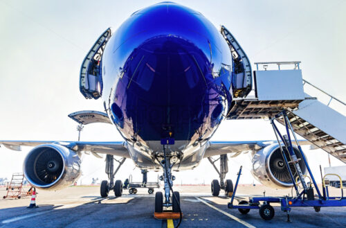 Fueling and final checking aircraft before taking off, view of open doors, turbines and boarding stairs, plane landing gear - Starpik