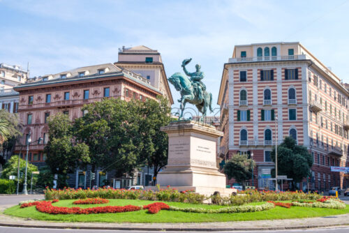 GENOA, ITALY – AUGUST 05, 2018: Piazza Corvetto at daylight with Vittorio Emanuele II equestrian statue. Buildings and bright blue sky - Starpik