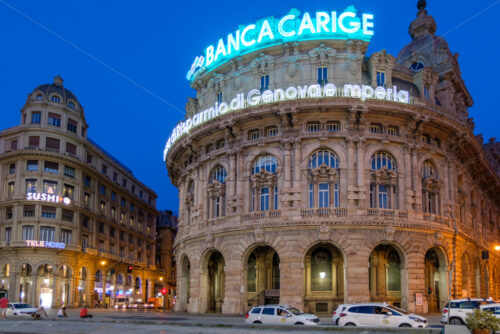 GENOA, ITALY – AUGUST 05, 2018: Piazza De Ferrari with buildings at night blue hour. People on promenade having fun - Starpik