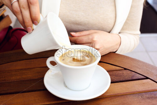 Girl in white suite drinking a cup of coffee in the morning - Starpik