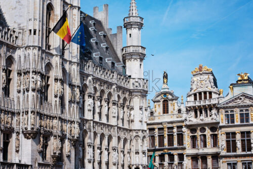 Grand place in Brussels with golden ornaments and blue sky, flags of European Union, Belgium - Starpik