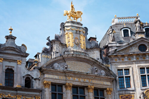 Grand place in Brussels with golden ornaments and blue sky, sculpture man on horse, Belgium - Starpik