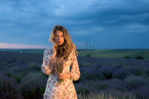 Happy blonde woman in lavender field at sunset in Moldova, summer flowers dress - Starpik