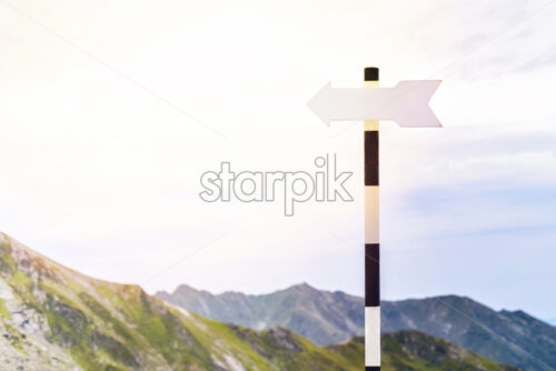 Informative arrow sign. Fagaras Mountains and cloudy sky on background. Romania beauties - Starpik