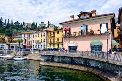 LOMBARDY, ITALY – AUGUST 01, 2018: People walking in Menaggio town. Waterfront view. Cloudy sky on background - Starpik