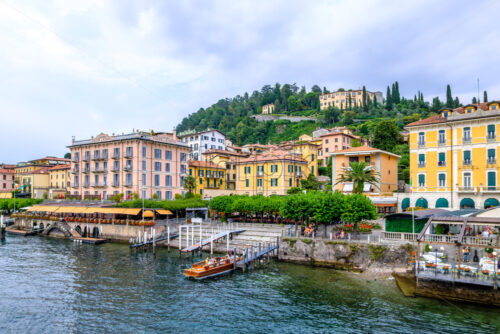 LOMBARDY, ITALY – AUGUST 03, 2018: Bellagio city shore with people and parked cars. View from Lake Como - Starpik