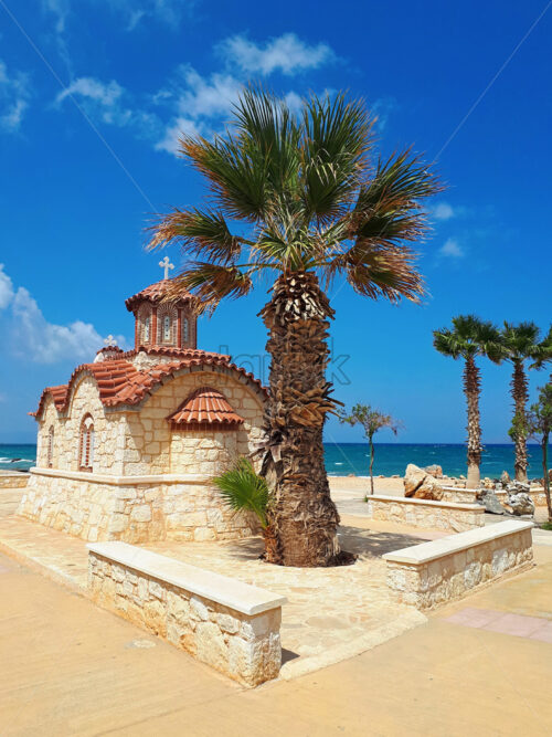 Local church and palm trees near sea and beach with blue sky in heraklion, crete island, greece - Starpik