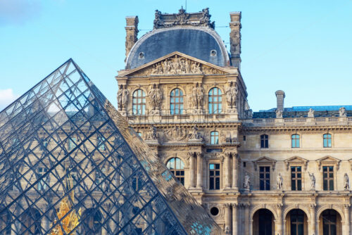 Louvre museum in orange and teal. Close up shot to a touristic atraction in Paris, France. No refelctions on the pyramid. Blueish tone on the building - Starpik