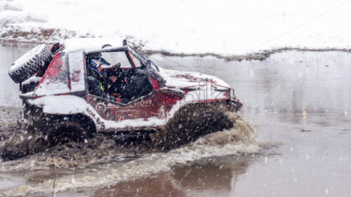 MAGDACESTI, MOLDOVA – MARCH 18, 2018: Jeeps compeating in winter rally competition with mud and snow. - Starpik