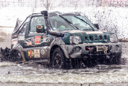 MAGDACESTI, MOLDOVA – MARCH 18, 2018: Jeeps compeating in winter rally competition with mud and snow. - Starpik