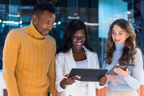 Multiracial group of people in an office discussing business using tablets - Starpik