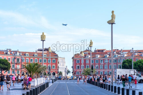 NICE, FRANCE – AUGUST 08, 2018: Place Massena at daylight. Plane above buildings. People on promenade - Starpik