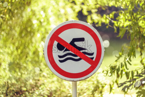 No swimming sign in park of the city. Sunny day on background. Close-up shot. Bucharest, Romania - Starpik