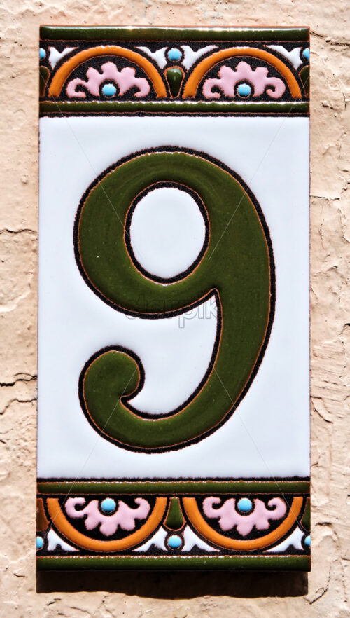 Number 9 painted on a tile of the wall. Bruges, Belgium - Starpik