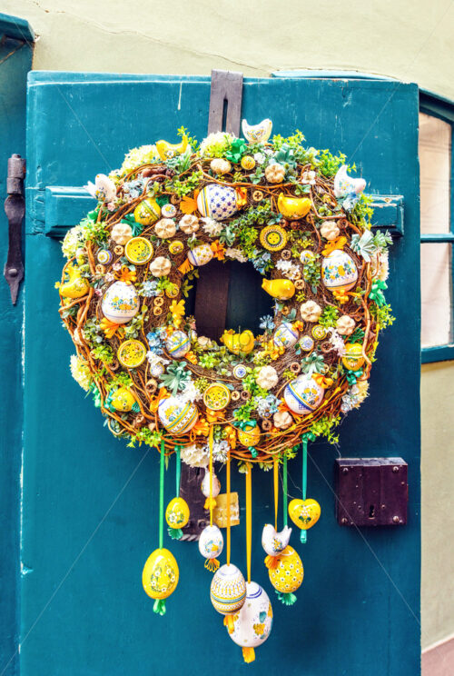 Old front door ornamented with colorful easter wreath. Birds, painted eggs and buttons. Prague, Czech Republic - Starpik