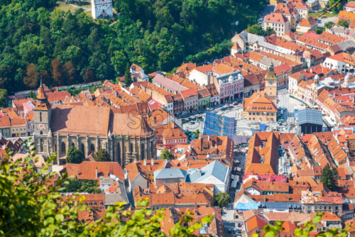 Overhead view of Black Church near Council Square in Brasov. Green forest near beautiful old city. Top view - Starpik