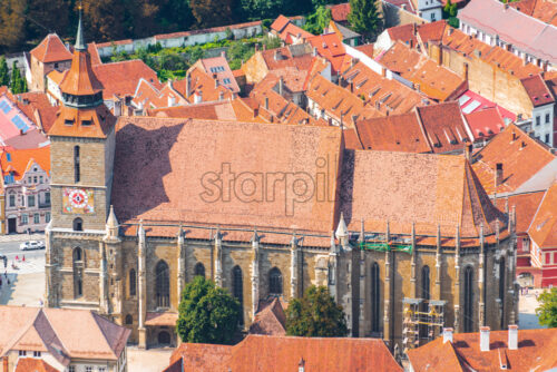 Overhead view of Black Church near beautiful old buildings in daylight in Brasov. Famous sights of the city - Starpik