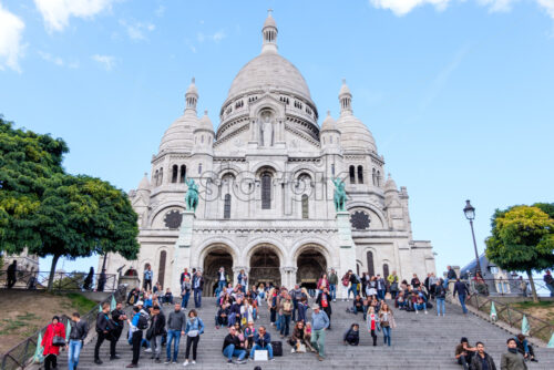 PARIS, FRANCE – OCTOBER 01, 2018: Wide angle view to the stairs leading to Sacre Coeur Basilica in Paris. Very busy day with lots of tourists. Blue sky with no clouds. White building - Starpik