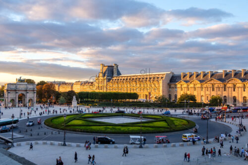 PARIS, FRANCE – OCTOBER 03, 2018: Close up shot to Louvre a part of Louvre from the side. Lots of tourists on the road. Bright and warm sunlight hitting the building - Starpik