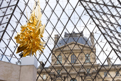 PARIS, FRANCE – OCTOBER 03, 2018: Kohei Nawa artwork at the entrance of Louvre pyramid. Golden throne shot horizontaly. Blue sky in the background. 3D looking object mesh - Starpik