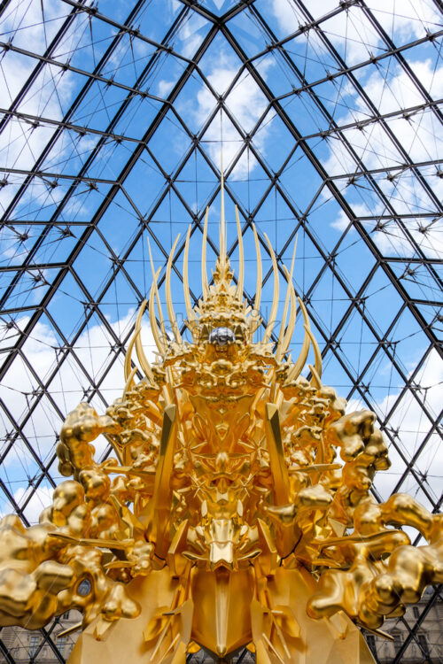 PARIS, FRANCE – OCTOBER 03, 2018: Kohei Nawa artwork at the entrance of Louvre pyramid. Golden throne shot verticaly respecting symmetry - Starpik