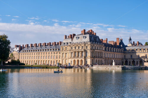 PARIS, FRANCE – SEPTEMBER 09, 2018: Pond in the yard of The Palace of Fontainebleau at daylight. People on boats and relaxing on shore - Starpik