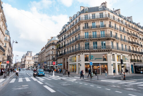 PARIS, FRANCE – SEPTEMBER 28, 2018: Orange and teal look to a street in Paris. People crossing the road and few cars in the trafic. Wide angle view - Starpik