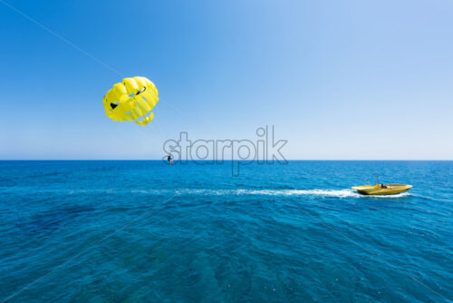 Photo of sea in protaras, cyprus island with parasailing and a boat. - Starpik