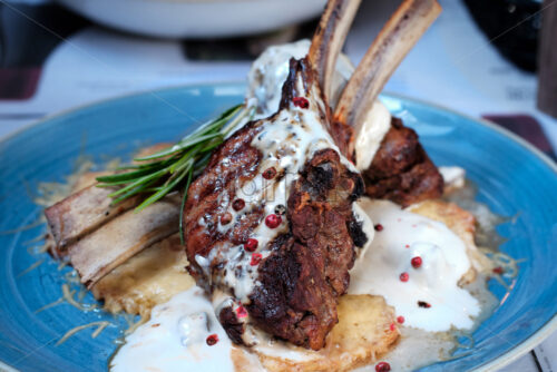 Pork ribs in white sauce on blue dish. Close-up shot - Starpik