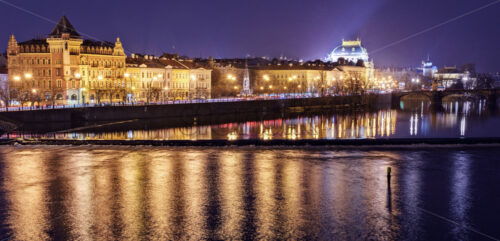 Prague city with warm lights glowing on streets and reflecting on water and ground in a rainy day. Legion Bridge on background. Negative copy space, place for text. Czech Republic - Starpik