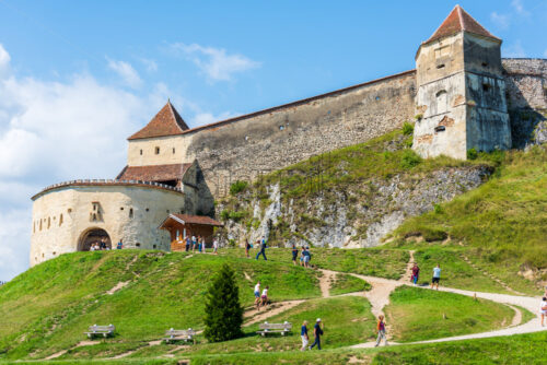 RASNOV, ROMANIA – AUGUST 18, 2019: People walking near Rasnov Citadel in sunlight. Bottom view - Starpik