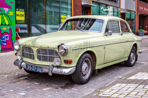 ROTTERDAM, NETHERLANDS – MAY 12, 2018: Old retro Volvo car parked on street pavage. Shops on background. - Starpik