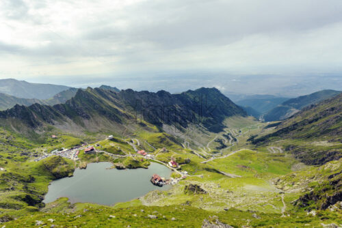 Scenery of Balea Lake and serpentine road in Fagaras Mountains, Romania. Cloudy sky. Wide shot - Starpik