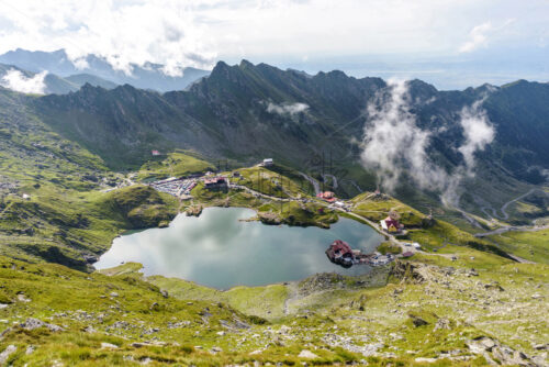 Scenery of Balea Lake in Fagaras Mountains, Romania. Cloudy sky above. Wide shot - Starpik